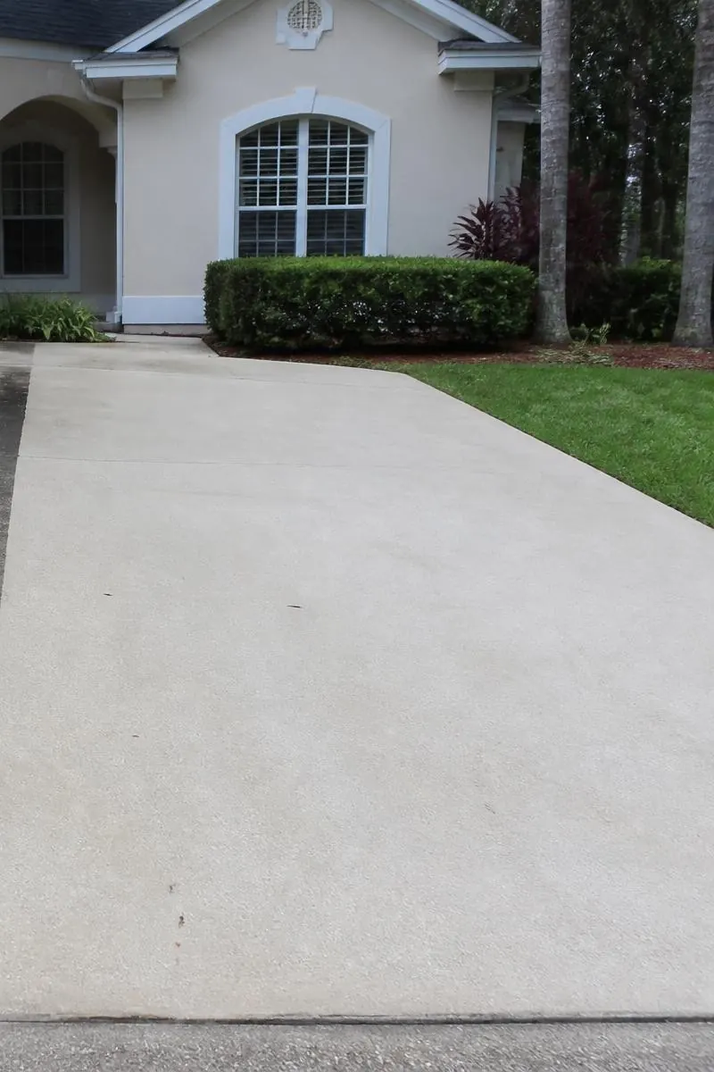 Concrete driveway restored to clean, uniform finish after pressure washing